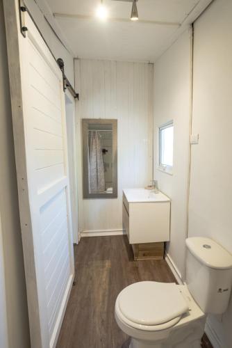 a white bathroom with a toilet and a sink at cabañas riveras rentals in Algarrobo
