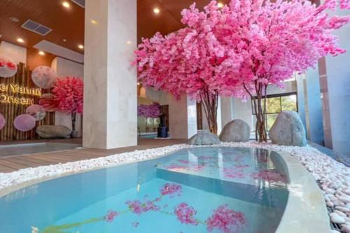 een zwembad met roze bloemen in de lobby van het hotel bij Genting Peak 3PaxStudio412 @Ion Delemen in Genting Highlands