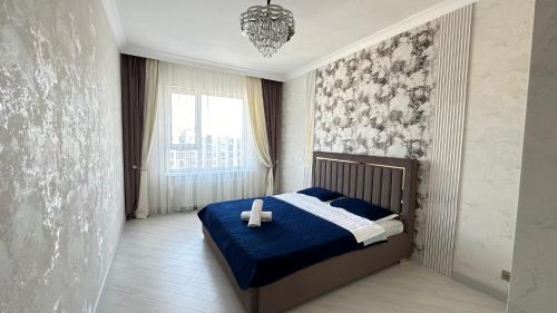 ein Schlafzimmer mit einem Bett mit Kreuz darauf in der Unterkunft 2х комнатные апартаменты 12-106 in Almaty