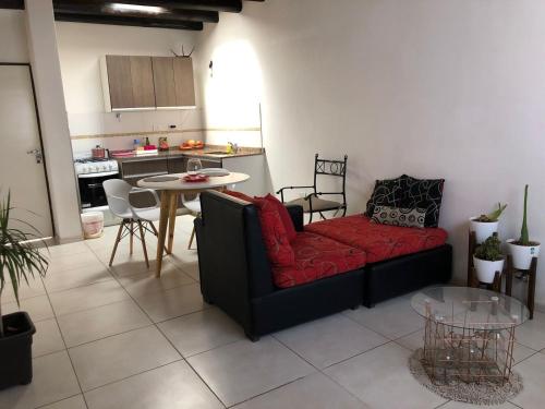 a living room with a red couch and a table at AeroSuites in Las Heras