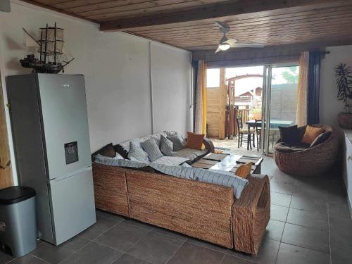 ein Wohnzimmer mit einem Sofa und einem Kühlschrank in der Unterkunft Le Latanier in Petite Île