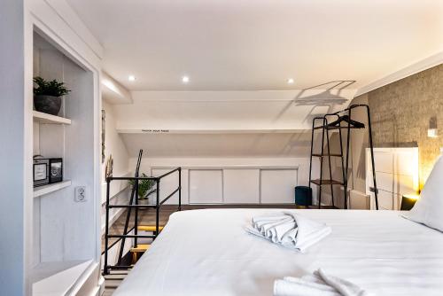 a bedroom with a bed with white sheets at Loft 29 in Zandvoort