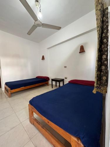 a bedroom with two beds and a ceiling fan at Seven Heaven Hotel And Diving Center in Dahab