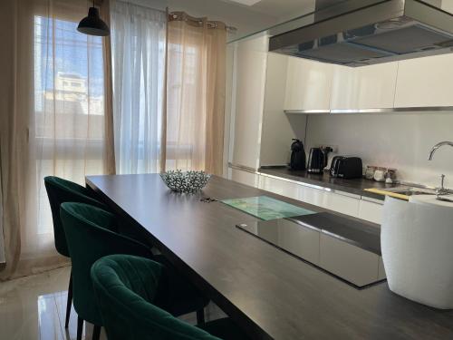 a kitchen with a counter with green chairs in it at 161 Maranello Court, Apartment 1 in Marsaxlokk