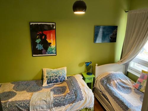 two beds in a room with green walls at Jeja Roosintie 6 in Hanko