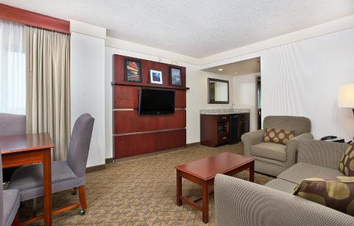 a living room with a couch and a tv in a hotel room at Holiday Inn University Plaza-Bowling Green, an IHG Hotel in Bowling Green