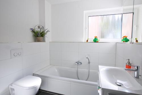 a white bathroom with a tub and a sink at Moderne 3-Zimmerwohnung Rottweil Zentrum in Rottweil