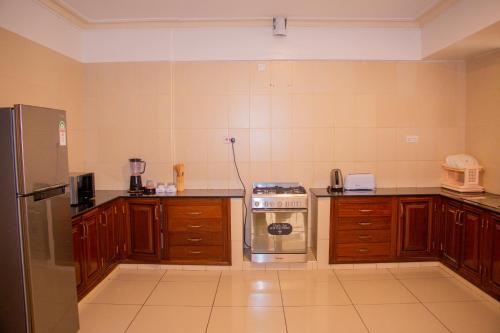 a kitchen with a stove and a refrigerator at Jumeirah Beachfront in Mombasa