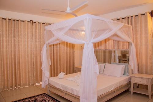 a bedroom with a bed with a canopy at Jumeirah Beachfront in Mombasa