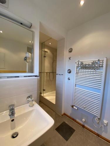 a white bathroom with a sink and a shower at Ferienwohnungen Ostsee & Mehr in Heringsdorf