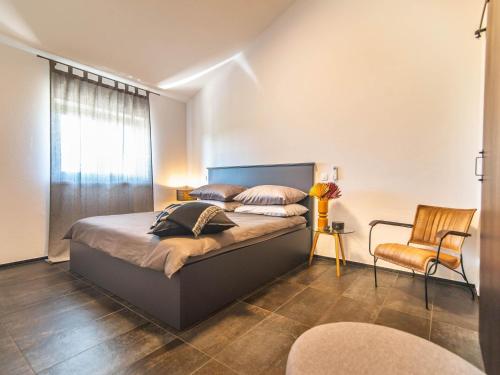 een slaapkamer met een bed, een stoel en een raam bij Luxury and stylish villa with private pool and terrace in Poreč