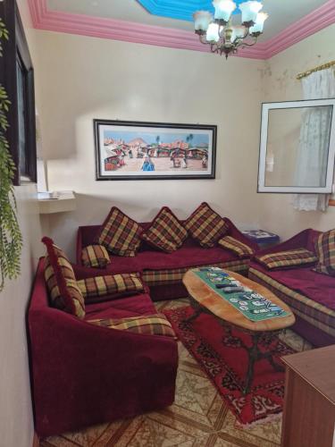 - un salon avec des canapés et une table dans l'établissement Maison bord de mer, à Zaouia Sidi Ouaggag