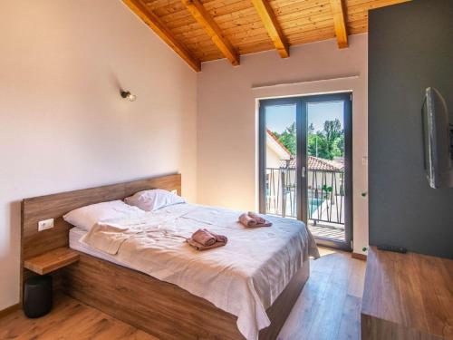 a bedroom with a bed and a large window at Large luxury villa with swimming pool and outdoor kitchen in Svetvinčenat