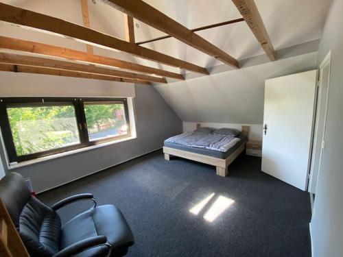 a room with a bed and a chair and a window at Ferien-Villa direkt am Rhein Sauna/Whirlpool in Götterswickerhamm