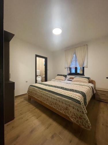 a bedroom with a large bed with a window at Konačište Zaplanjsko ognjište in Donji Dušnik