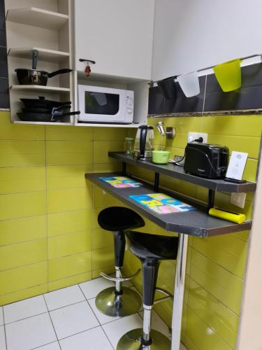 une cuisine avec un comptoir avec des tabourets et un four micro-ondes dans l'établissement maison de ville, à Redon