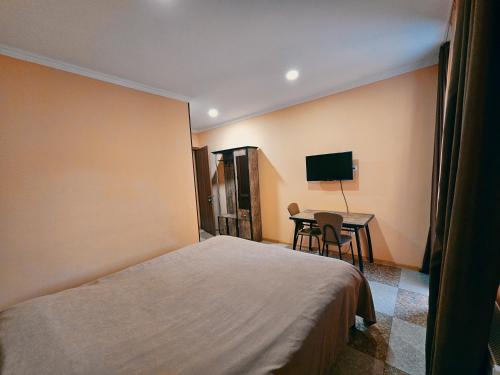 um quarto de hotel com uma cama e uma mesa em Tourist Complex Khomi em Ch'argali