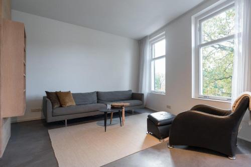 a living room with a couch and a table at City centre Loft on the historic Canal in Utrecht