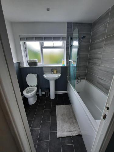 a bathroom with a toilet and a tub and a sink at Taunton Central in Taunton