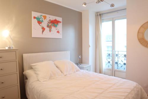 een slaapkamer met een wit bed en een raam bij Résidence Poste & Golf, appartement pour 4 personnes au cœur de Luchon in Luchon