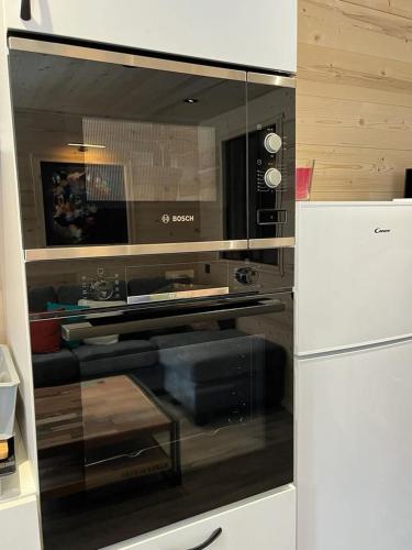 a kitchen with a refrigerator and a table in it at Les appartements de Makalu Val Thorens in Val Thorens