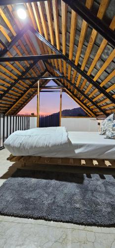 a bed under a wooden structure with a roof at Snow Biscuit Huts in Dharamshala