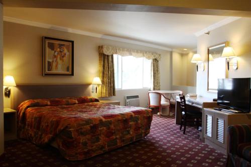 a hotel room with a bed and a desk at Metro Plaza Hotel in Los Angeles