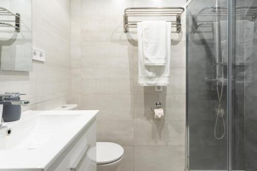e bagno con doccia, servizi igienici e lavandino. di Moderno y cómodo apartamento en calle Vargas a Santander