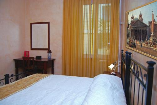 a bedroom with a bed and a desk and a window at Maestoso Locazione Turistica in Rome