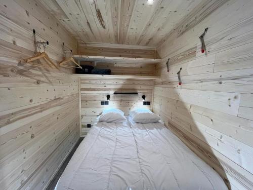 a large white bed in a wooden room at Les appartements de Makalu Val Thorens in Val Thorens