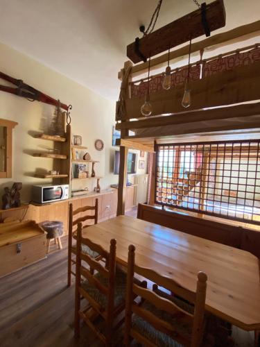 - une salle à manger avec une table et des chaises en bois dans l'établissement IL COVO DELLO SCIATORE, à Falcade