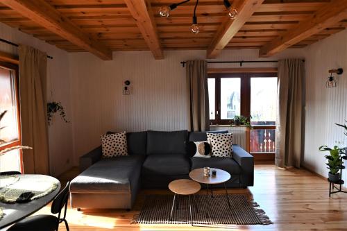- un salon avec un canapé noir et une table dans l'établissement Apartmán s krbom vedľa Zubačky, à Tatranska Strba