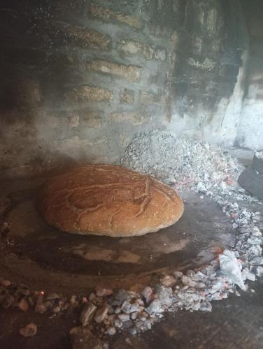 a loaf of bread cooking in a brick oven at Fruskogorske brvnare in Velika Remeta