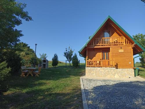 a log cabin with a picnic table in a field at Fruskogorske brvnare in Velika Remeta