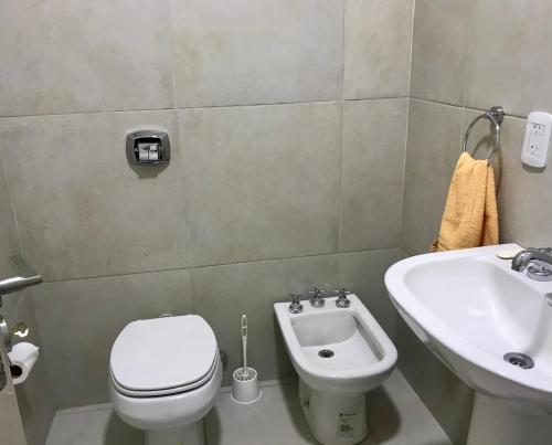 a bathroom with a toilet and a sink at Avenida Departamento completo, cerca de todo in San Nicolás de los Arroyos