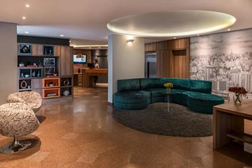 a living room with a green couch and a table at Flat Triplo - 50 m Av Paulista - By Palm Rooms - 129 in Sao Paulo