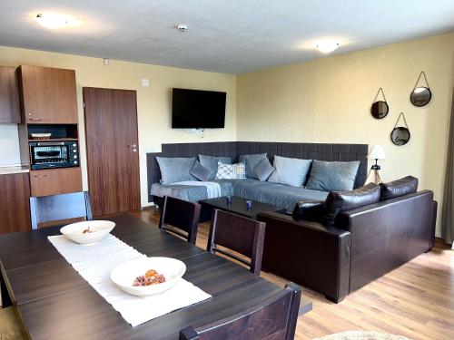 a living room with a couch and a table at Private Suite at Comfort Bansko in Bansko