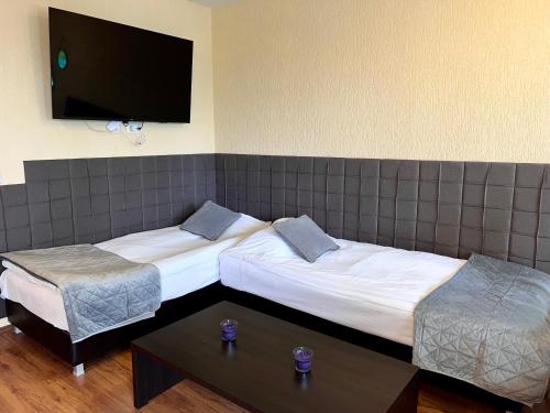 a hotel room with two beds and a flat screen tv at Private Suite at Comfort Bansko in Bansko