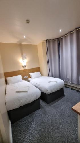 um quarto de hotel com duas camas e uma janela em 48 The Brent em Kent