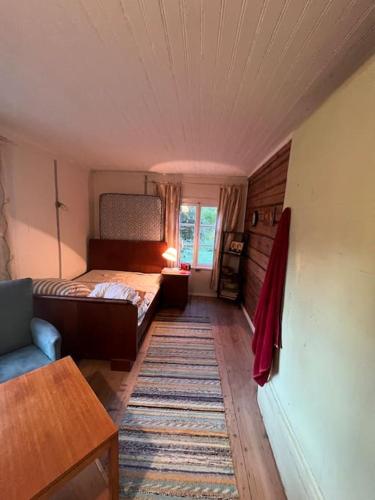 a small bedroom with a bed and a rug at Privaatne talu otse mere ääres in Tahkuranna