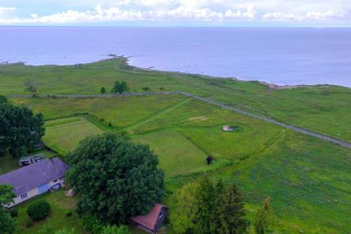 an aerial view of a green field with the ocean at Privaatne talu otse mere ääres in Tahkuranna