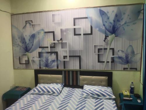 ein Schlafzimmer mit einem Bett mit blauen und weißen Blumen an der Wand in der Unterkunft OYO Home Safe In in Rohtak