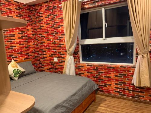 a brick room with a bed and a window at Homestay 9view thủ Đức in Ho Chi Minh City