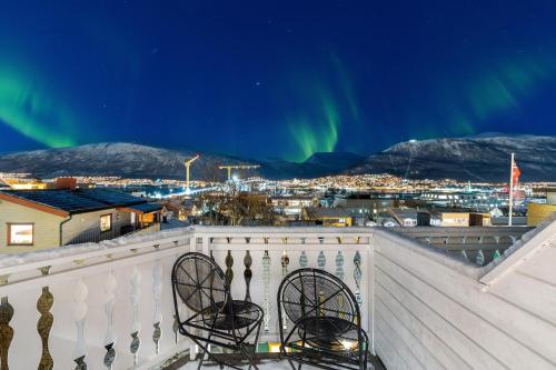 widok na zorzę polarną z balkonu z dwoma krzesłami w obiekcie Arctic Homes - Majestic View w mieście Tromsø