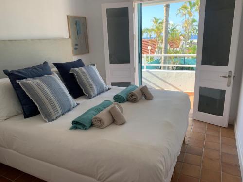 a large white bed with three pillows on it at Vivienda Vacacional Pasito Blanco 1 in Pasito Blanco