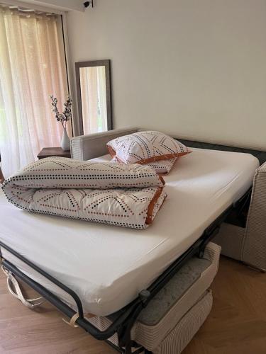 a bed with four pillows on top of it at La perle du parc - Studio in Rocquencourt