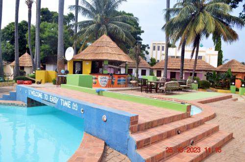 a resort with a swimming pool and a restaurant at Easy Time Lodge in Kololi
