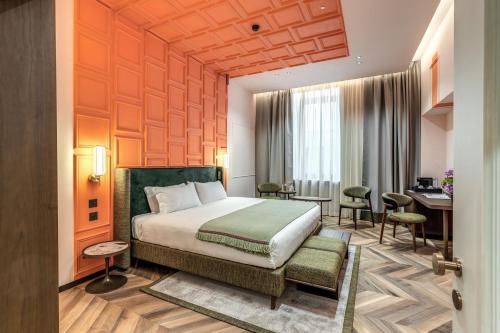 ローマにあるEitch Belsiana Relaisのベッドとデスクが備わるホテルルームです。