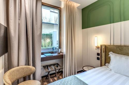 a hotel room with a bed and a window at Eitch Belsiana Relais in Rome