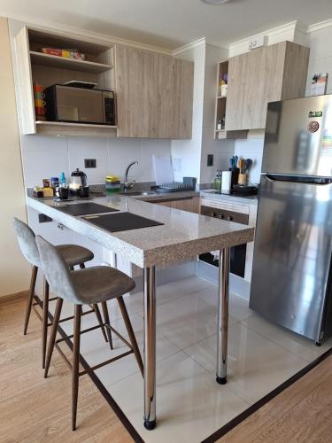 a kitchen with a counter and a refrigerator at Departamento Centro Lynch II in Temuco